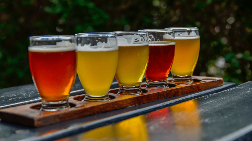 Πέντε ποτήρια με μπίρα πάνω σε μια ξύλινη βάση